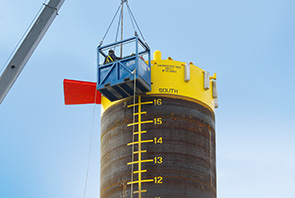 Workers paint identification marks on a suction pile for the Bonga North West oil field development off the coast of Nigeria (photo)