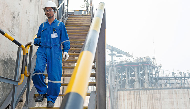 Worker doing a routine inspection at the Hazira LNG receiving and regasification terminal, a joint venture between Shell and Total, in India. (photo)