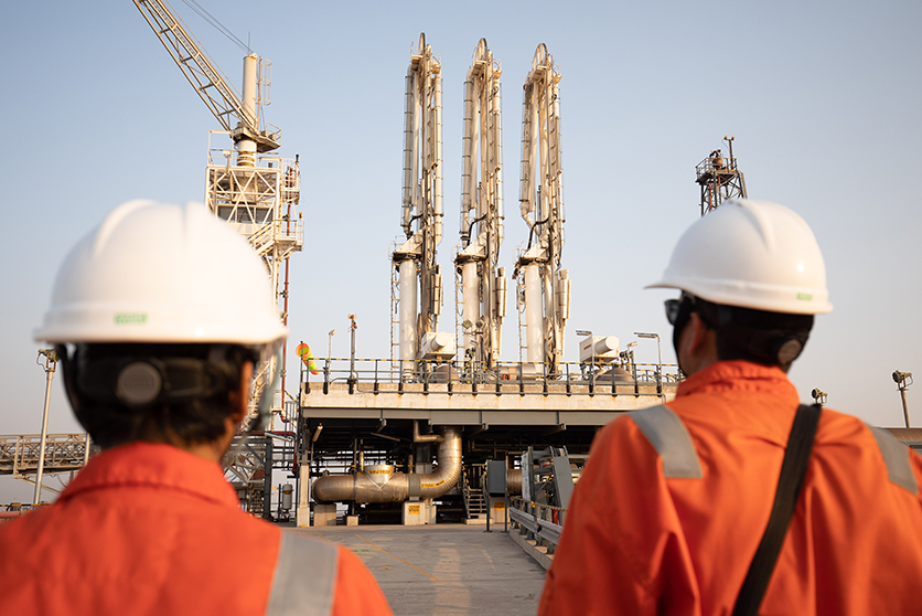 Operators looking at pipework at Hazira LNG port and terminal, India (photo)