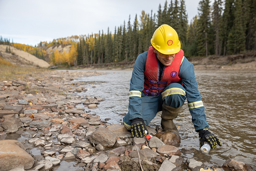 An employee taking a sample of the river water as part of the safe and responsible water management in action at Fox Creek, Canada (photo)