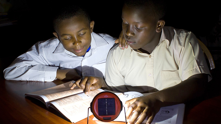 Two boys study using the Dlight innovation (photo)