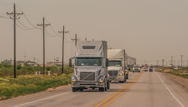 Trucks on a road near the Permian Basin, USA. (photo)