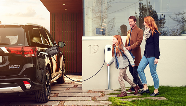 A family walking towards their electric vehicle. (photo)