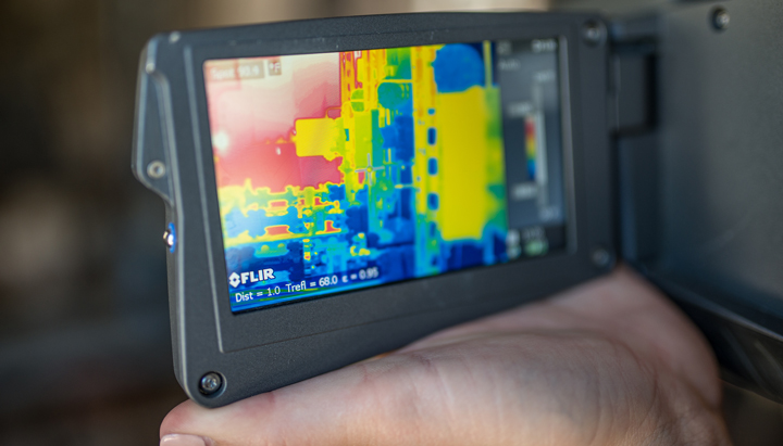 An employee at a well pad inspects with her infra-red camera detecting any potential dangerous gases or leaks (photo)