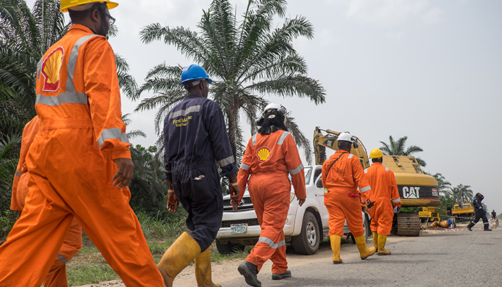 Members of the Shell Nigeria spill response/remediation team walking along a road. (photo)