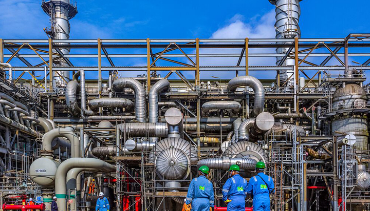 Three people looking at the NLNG plant in Bonny, Nigeria. (photo)