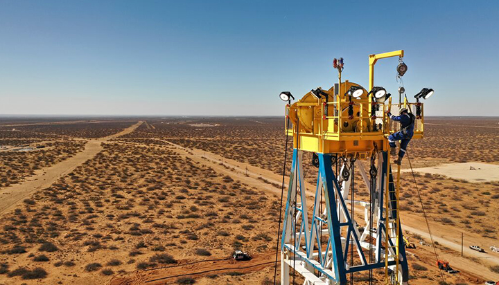 A man climbing up a drilling rig in the Permian Basin, Texas, USA. (photo)