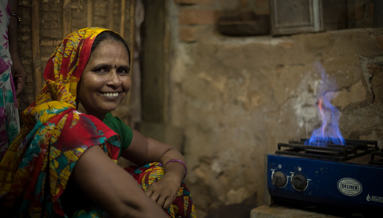 A woman cooking food on a biogas burner. (photo)