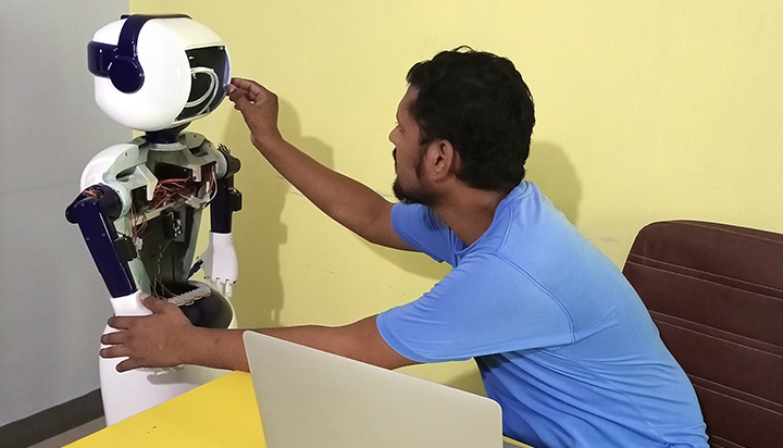 Man sitting next to an Edvon robot (photo)