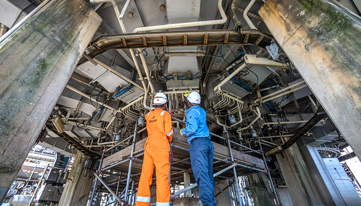 Two men inspecting equipment at the NLNG plant in Bonny, Nigeria. (photo)