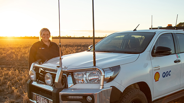 Australian Shell QGC employee standing beside her vehicle in the fields. (photo)