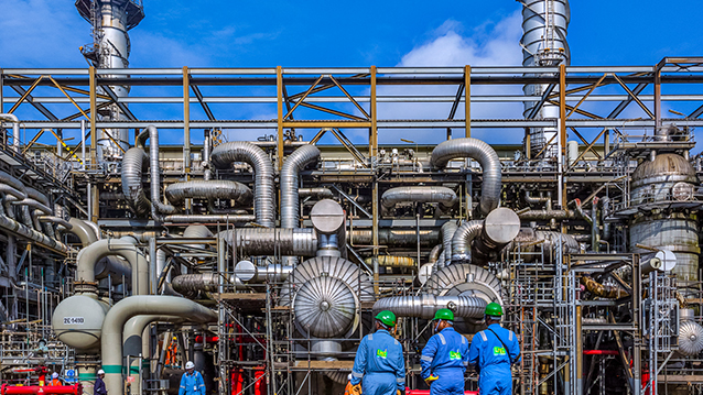 Three people looking at the NLNG plant in Bonny, Nigeria. (photo)