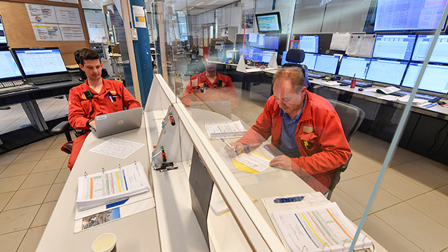 Two men with a plastic screen between them. working in a control room at Moerdijk, in the Netherlands. (photo)