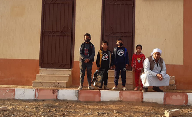 A man and four boys standing outside a building in the Western Desert, Egypt. (photo)