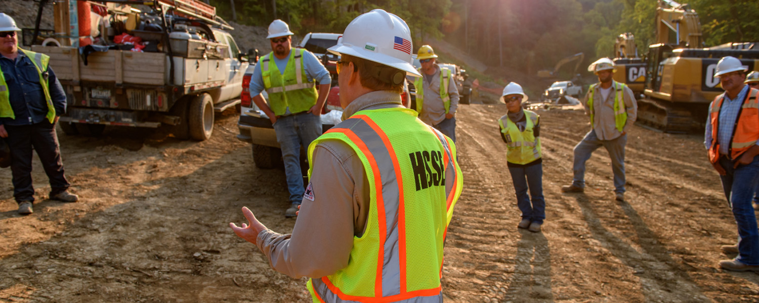 Socially-distanced construction workers attending a morning HSSE briefing in the USA. (photo)