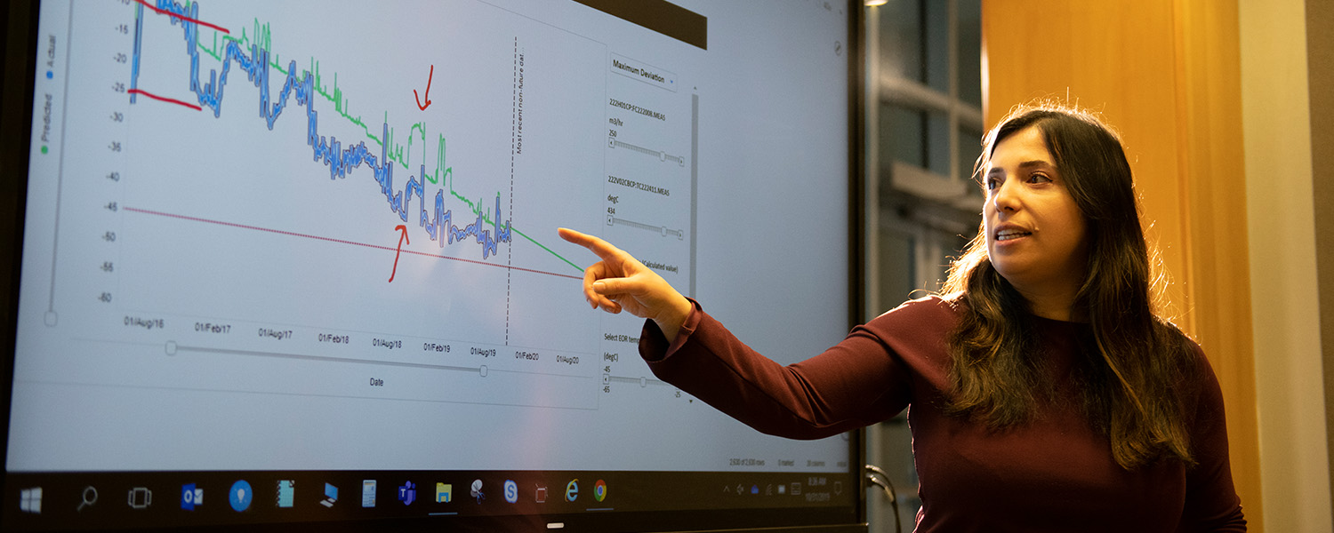 A woman presenting data shown on a large screen in Alberta, Canada. (photo)