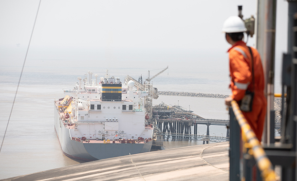 Man looking at a ship in Hazira (photo)