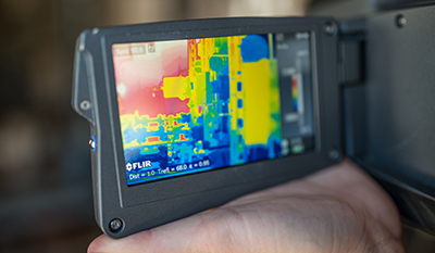A person using an infrared camera to look for potential gas leaks (photo)