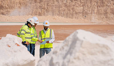 Three men discussing and looking at a clipboard (photo)