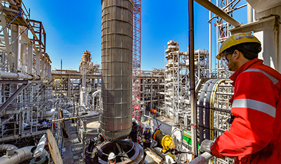 Man watching colleagues working at a refinery (photo)