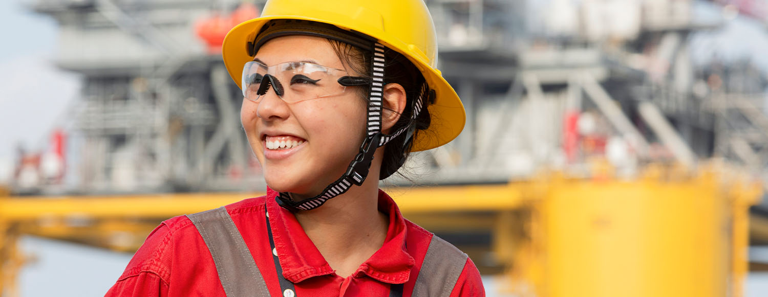 woman in PPE smiling in front of Whale platform (photo)