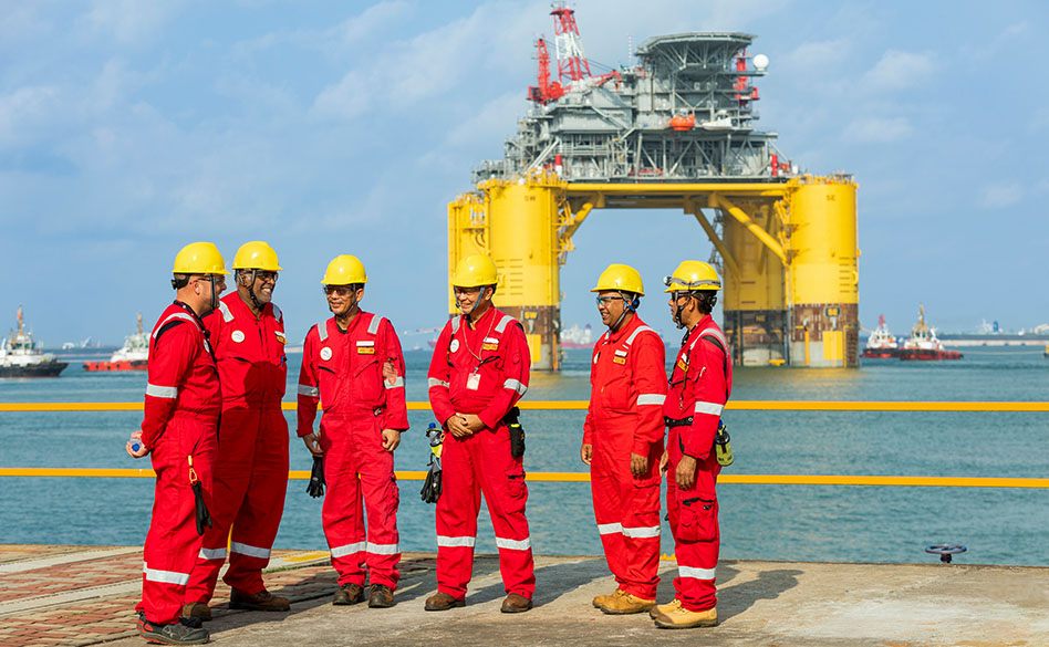 group of men wearing PPE having a Safety briefing on a helipad (photo)