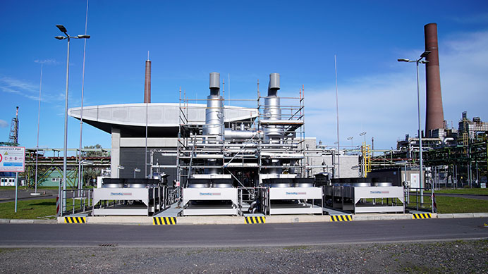 Industrial equipment with a chimney and futuristic structures under a blue sky (photo)