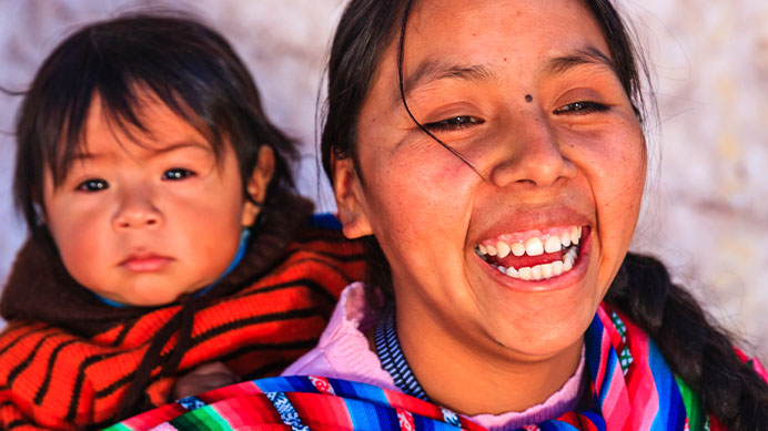 Mother with baby daughter in sling on her back