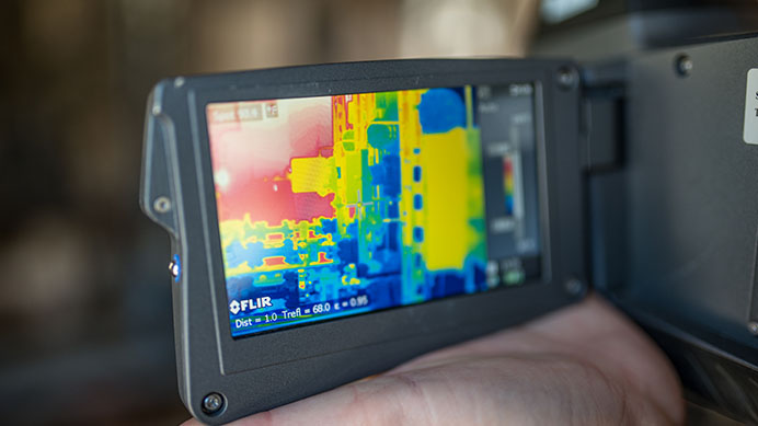 An employee at a well pad inspects with her infra-red camera detecting any potential dangerous gases or leaks (photo)