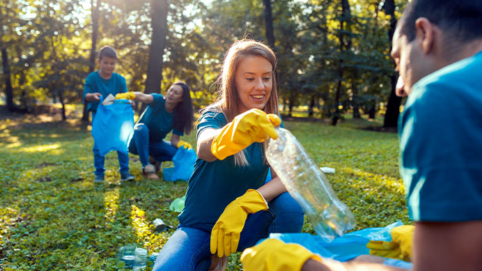 A worker in an orange safety shirt holds a bottle, with a cooler beside them (photo)